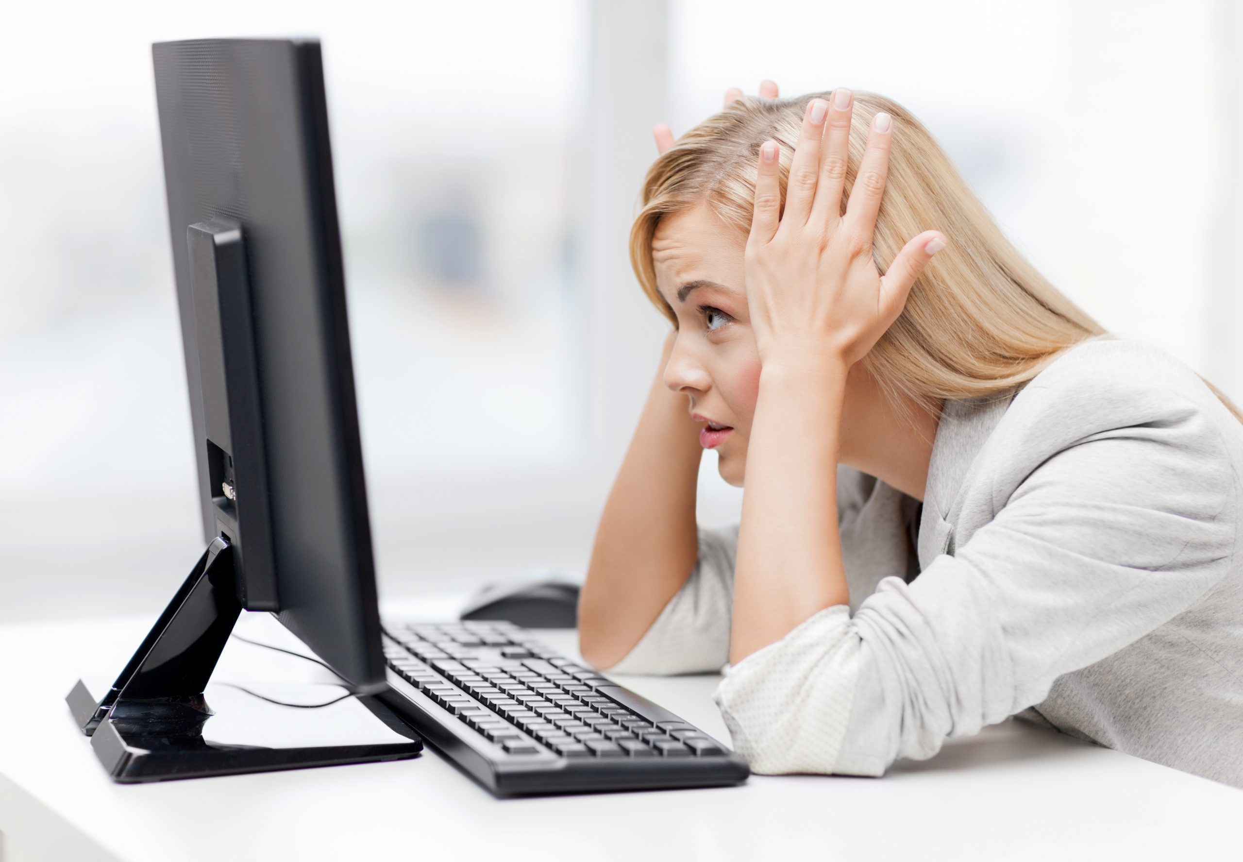 woman looking at computer with stressed expression
