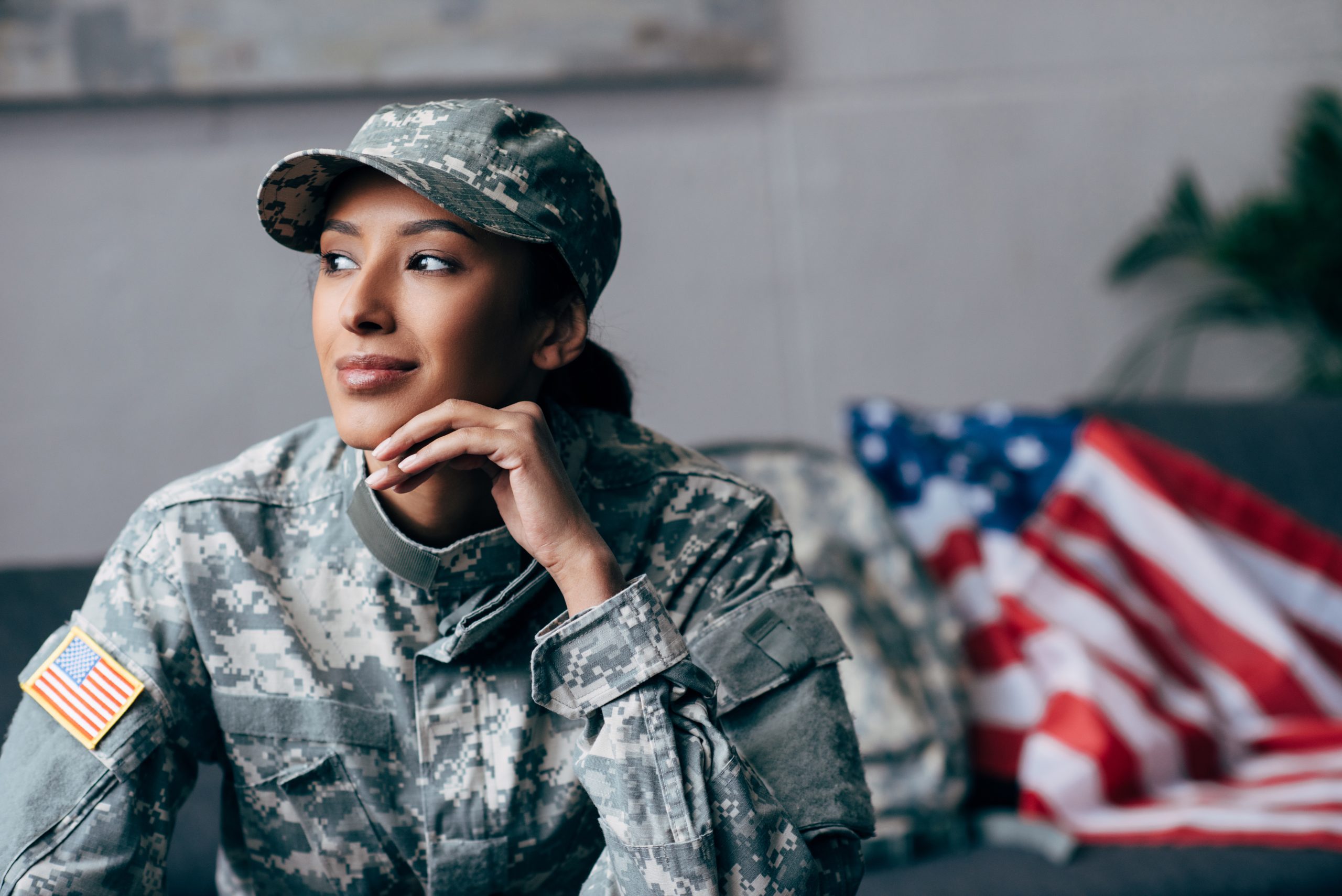 army woman sits in uniform with a flag